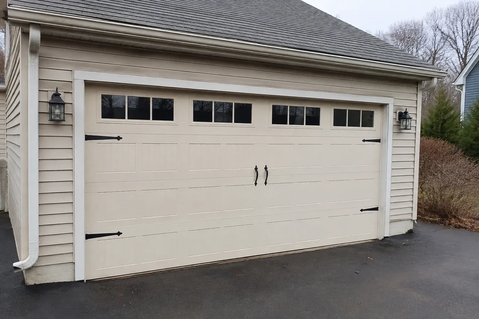 Cream carriage-house-style garage door with dark decorative hardware. — Carriage-House Garage Door Installation, Toronto